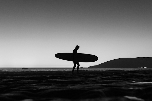 surfer walking on the beach with surfboard under arm (card)